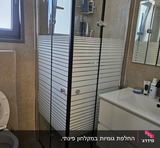 מקלחון זכוכית עם מדף ומוצרי טיפוח